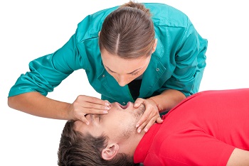 Image of woman performing mouth-to-mouth CPR